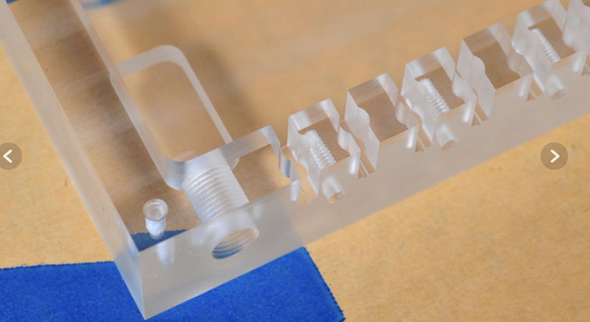 Thick clear acrylic block precision cut with slots and threaded holes