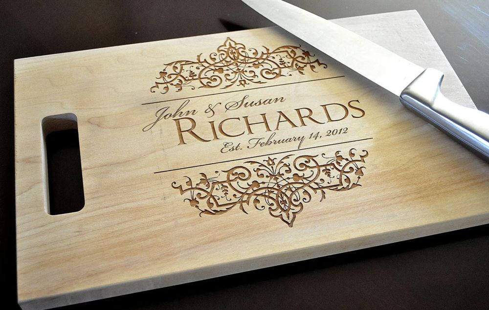 Maple cutting board engraved with a couple's names, wedding date and ornate scrollwork